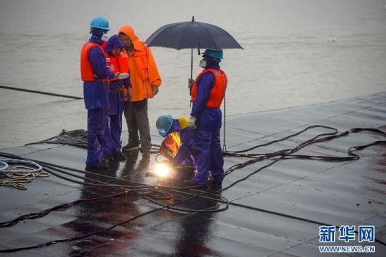 6月4日早晨8时许,救援人员在“东方之星”船底切割第三个探孔,继续进行生命探测。目前,救援人员已在翻沉的“东方之星”船底打开了两个探孔,但均未发现生命迹象。救援人员又迅速将这两个探孔封上。在现场指挥救援的中国船级社武汉分社总经理王志刚介绍,开孔是探测生命的最后一招。按照国际惯例,把72小时作为生命的标准线,在此之前要千方百计确定有无生命;如果72小时到了,确定没有生命,再把船翻过来,这是对生命的尊重。新华社记者 肖艺九 摄 图片来源:新华网