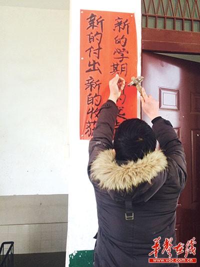 2015年3月，张友良书写几幅大字贴在学校走廊墙壁上，希望能给学校带来些新气象。 记者 雷昕 摄