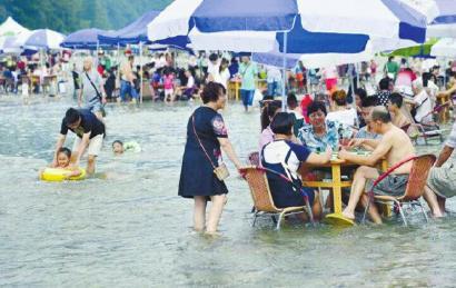 8月2日，都江堰虹口，游客水中搓麻将。朱建国摄