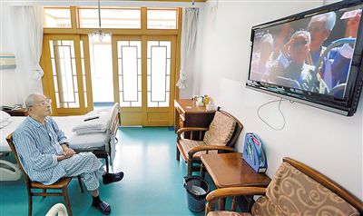 图为在南京军区南京总医院，87岁的抗战老兵王堃收看大会直播。