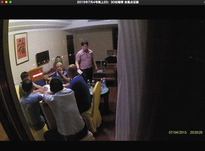 2015年7月4日，衡东县县委副书记谭建华（站立拿钱者）被偷拍到在一家酒店里赌博。视频截图