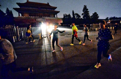故宫外围夜跑队伍中，只有少数人戴荧光脚环用于警示提醒