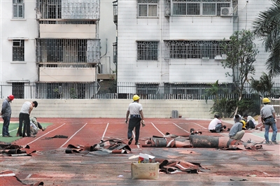 11月12日，工人们开始铲除深圳外国语中学初中部校园内的&ldquo;毒跑道&rdquo;。图/CFP