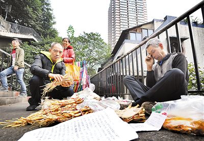 昨日,两路口到健康路的地下通道口,巫溪老人张家松摆摊卖山货,为2岁的白血病孙女挣药费。