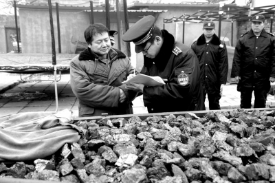 昨天上午，一名无照商贩在长辛店贩卖劣质煤被查。京华时报记者欧阳晓菲摄