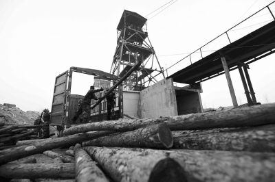 25日,武警官兵在搬卸用于支撑矿井巷道的木头。新华社发