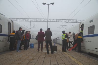 列车工作人员正在用梯子帮助旅客换乘。读者郭先生供图