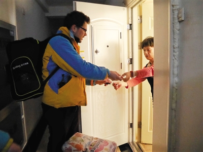 远洋天地小区，弗兰克将快递送到顾客手中。