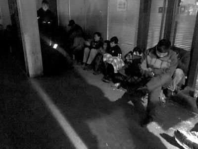 挂号人员蜷缩在门诊大楼外通宵排队。