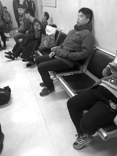 “老大”坐在门诊大厅观察挂号情况。