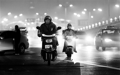 昨日晚餐时间，北京街头出现了众多骑着电动二轮车的外卖送餐员忙碌的身影。 摄影/本报记者 袁艺