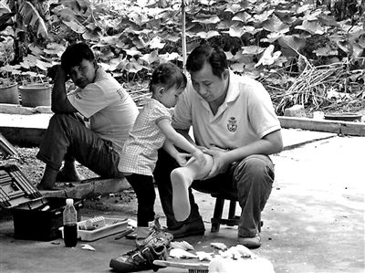 两岁的跳跳随父亲进村协助吴泽豪修理假肢