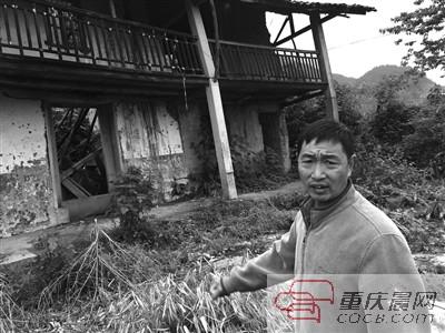 在邱宝财家门前,村支书谭仕良介绍当年情况。