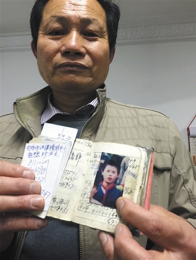 近日，年近六旬的江苏句容农民江志根展示儿子的照片。图/东方IC