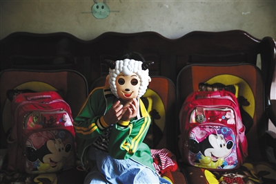 莎莎戴着喜羊羊面具，她很喜欢看动画片。