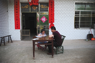 5月12日，赤塅完小校长尹鹏波每周来莎莎家里给她单独上数学课。A12-A13版摄影/新京报记者 薛珺