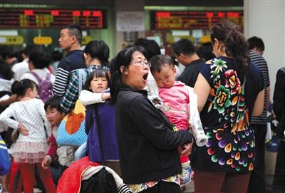 儿童医疗资源短缺是我国医改面临的难题之一。图为2014年5月9日,首都儿科研究所,一位家长抱着孩子排队挂号。资料图片/新京报记者 薛珺 摄