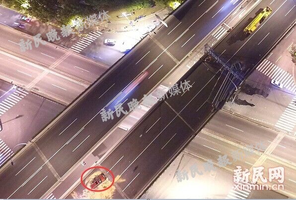 图说：图中红圈的小轿车事发时正撞上了翘起的桥面损毁严重 新民晚报新民网 萧君玮 摄