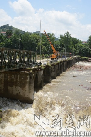 被洪水冲垮的叶家湾大桥断桥上正在架设钢桥.jpg