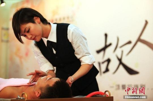 资料图:2014年12月17日,一场特殊的追思仪式——故人沐浴,在上海龙华殡仪馆举行。入殓师为亡者(模特)仔细地擦洗身体,穿好丧服,一丝不苟地画上妆容,最后虔诚祈祷,让逝者美丽离去。摄影:张亨伟