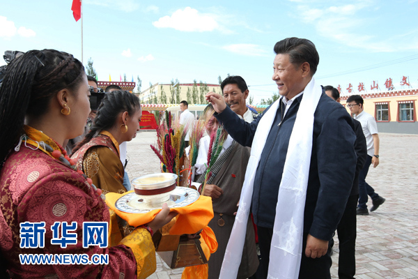 这是8月22日下午，习近平在海西蒙古族藏族自治州格尔木市唐古拉山镇长江源村考察时接受村民献上的青稞酒。 新华社记者 庞兴雷 摄