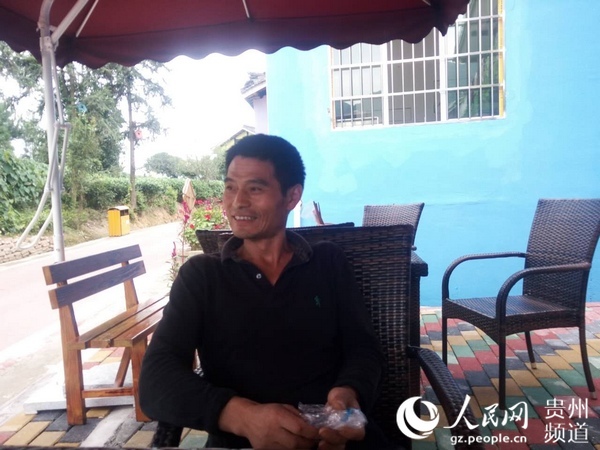 图为袁连国说到家乡的变化喜笑颜开。王钦 摄