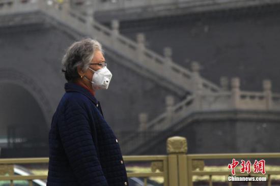 资料图：12月14日上午，西安民众戴口罩出行。 张远 摄