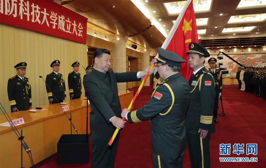 7月19日，新调整组建的军事科学院、国防大学、国防科技大学成立大会暨军队院校、科研机构、训练机构主要领导座谈会在北京八一大楼举行。中共中央总书记、国家主席、中央军委主席习近平向军事科学院、国防大学、国防科技大学授军旗、致训词，出席座谈会并发表重要讲话。这是习近平将军旗郑重授予国防科技大学校长邓小刚、政治委员刘念光。新华社记者 李刚 摄