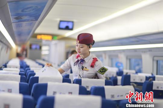 图为包娜对到站列车的座椅进行整理。　杨敏　摄