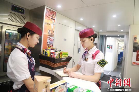 图为包娜和餐车人员对旅客的建议进行统计。　杨敏　摄