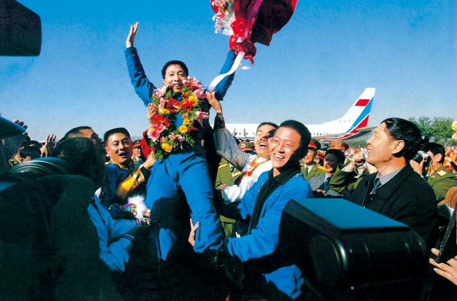 2003年10月16日 执行神舟五号任务航天员杨利伟返回西郊机场被欢呼的人群抛起 摄影：朱九通