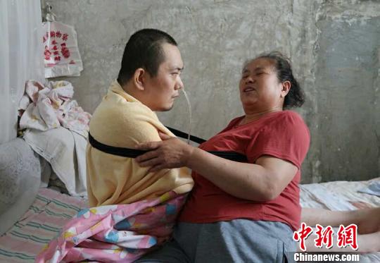 身体日渐衰老的梁青兰每次帮儿子翻身、坐立,全身的衣物都要湿透一次。 尚明侠 摄