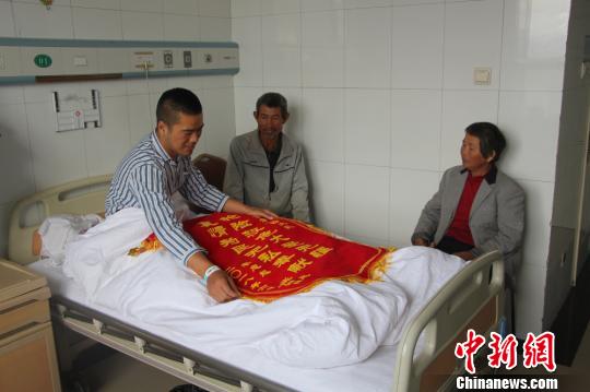 被救的李忠起、张总凤夫妇看望受伤后的李运飞。　汪渝 摄