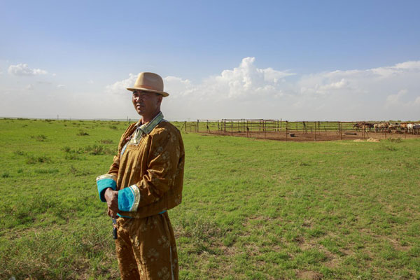 牧民苏 呼格吉勒图站在自家马场前眺望远方
