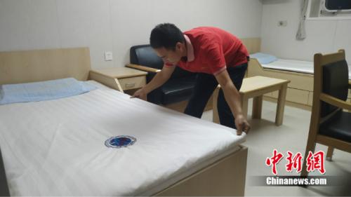 李红民在远望7号的住舱中铺床,如今的床铺干燥舒适,房间明亮宽敞。 温孟馨 摄 点击进入下一页