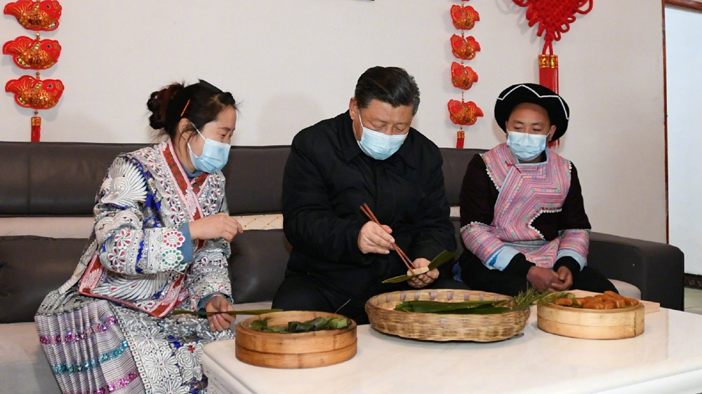 习近平同苗族村民包黄粑迎新春：祝你们日子过得更加甜美