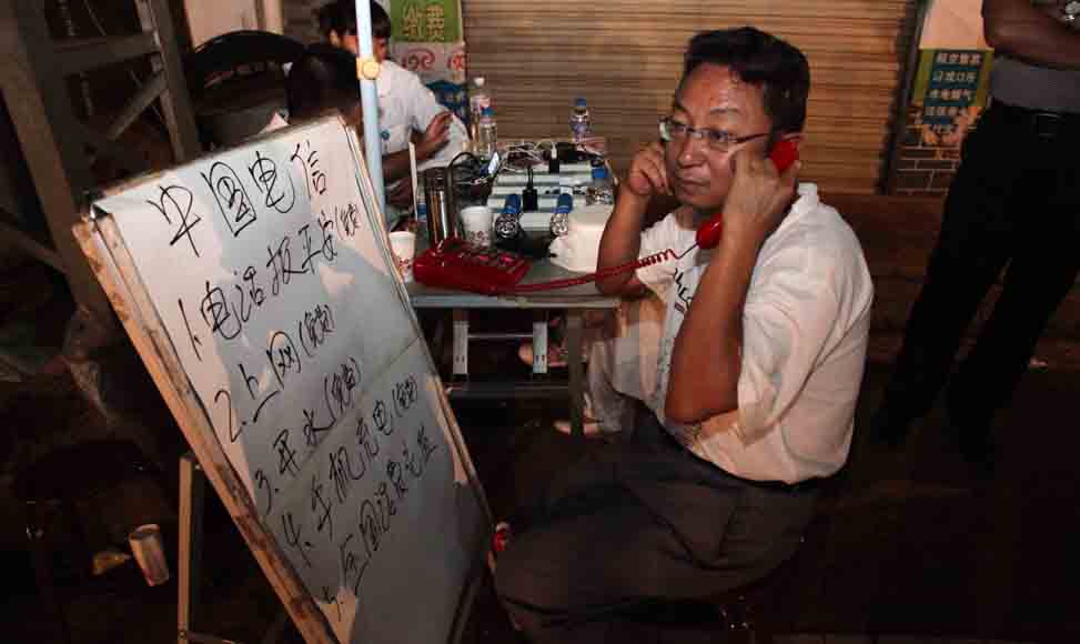 8月4日，一名灾区群众在巧家县包谷垴乡的电信服务网点拨打电话报平安。