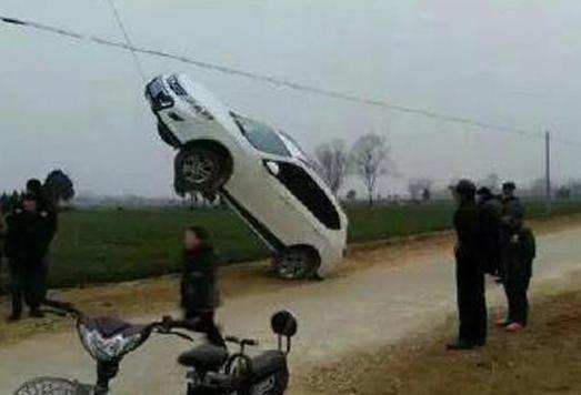 奇葩！司机竟将轿车开到电线杆拉索上