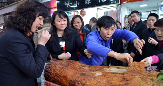 广州一妇婴用品店开业 烤猪遭“围抢”