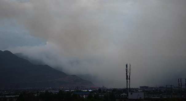 云南丽江古城区发生森林火情 城区可见浓烟