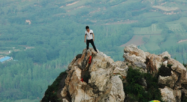 游客不惜危险 百米高悬崖绝壁上拍照留影