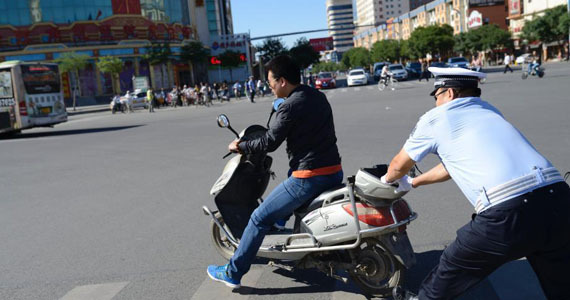 交警生拉硬拽阻止行人闯红灯