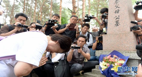 日本遗孤在哈尔滨祭拜中国养父母公墓