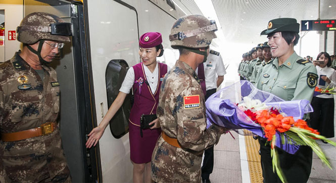 天安门参阅官兵乘专列回营 女兵捧花接站