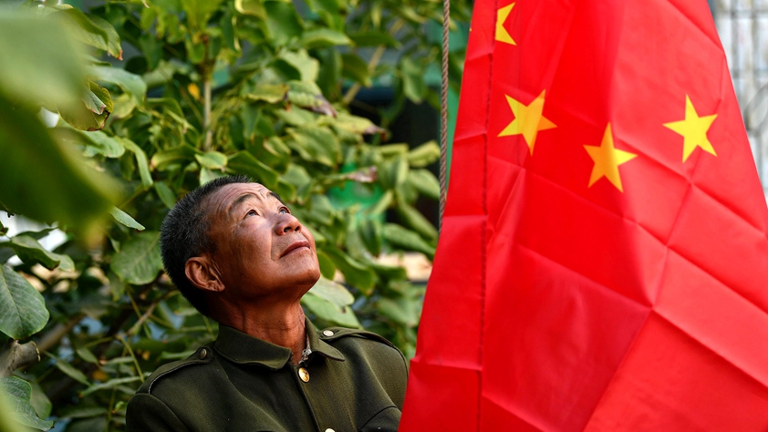 农家小院国旗升 爱国情映老农心