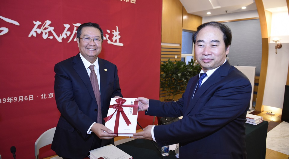 本书主编王定华向教育部原副部长、中国教育国际交流协会会长刘利民赠书