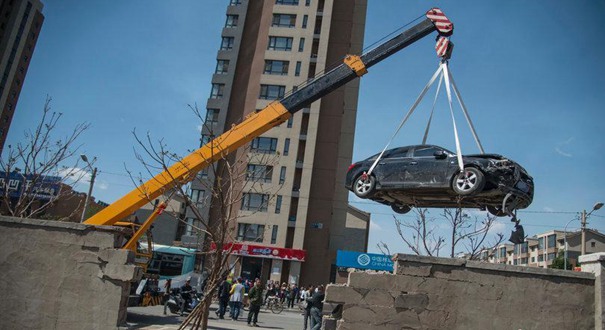 沈阳女司机开车卡墙中 救援人员拆墙移车