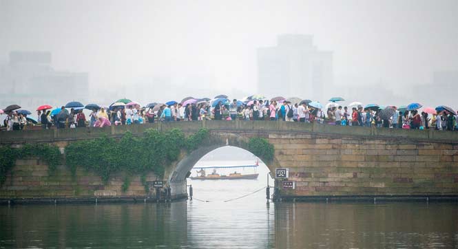 杭州游客爆棚 西湖断桥变&ldquo;伞桥&rdquo;