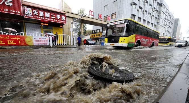 乌鲁木齐一路段窨井堵塞污水横流 市民上演&ldquo;水上漂&rdquo;