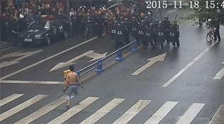 街头一幕：男子赤身手提砍骨刀对峙特警